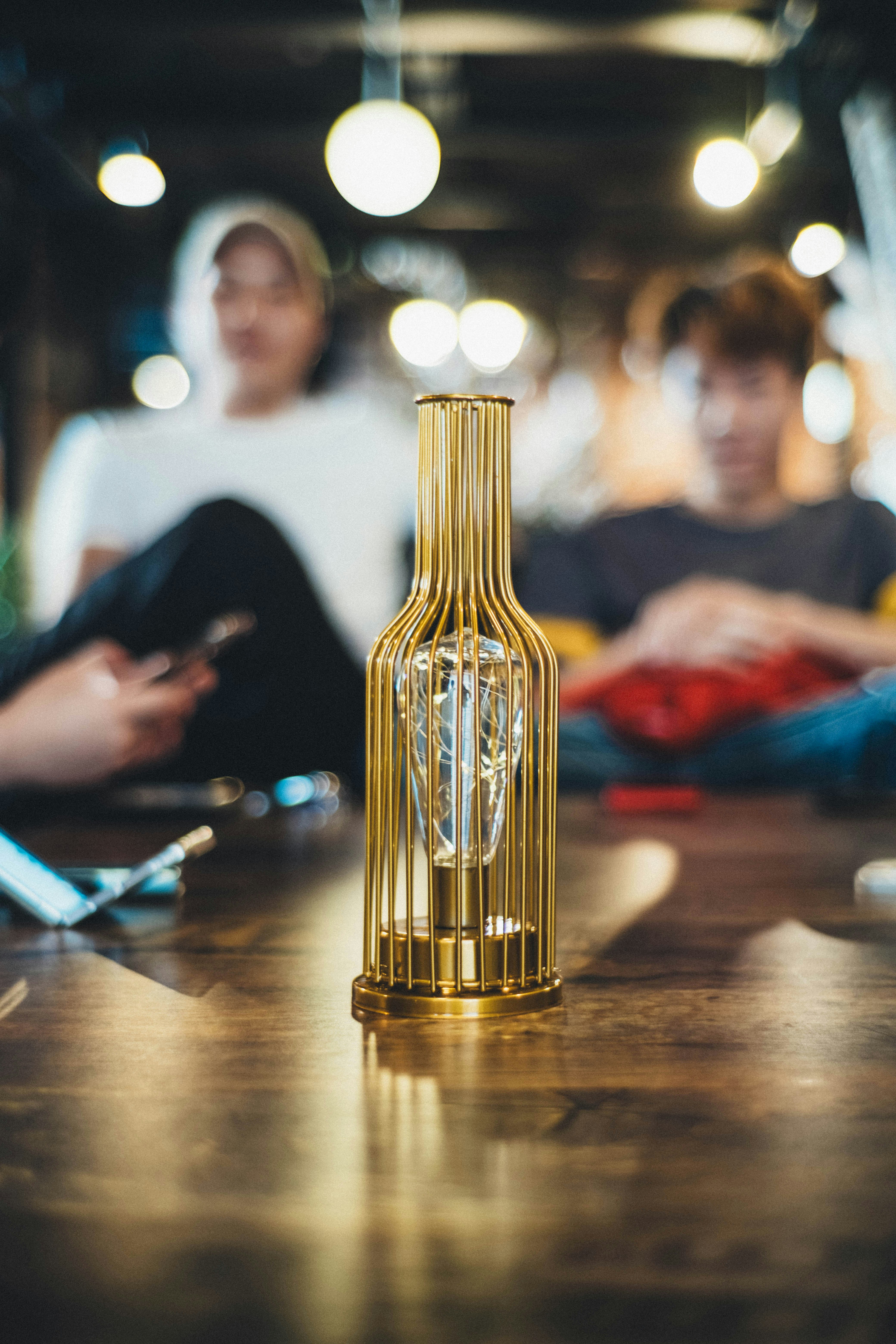 Una botella dorada sentada encima de una mesa de madera