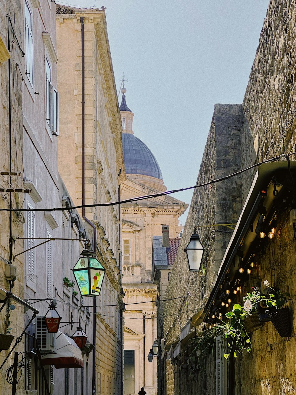 a narrow alleyway with a clock tower in the background