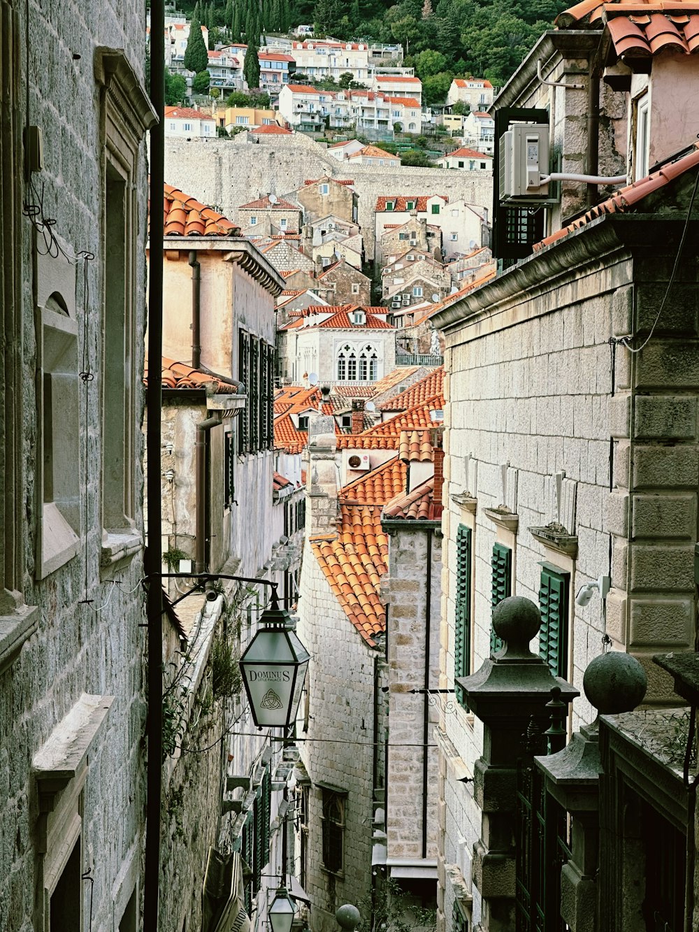 a narrow city street with buildings and a lamp post