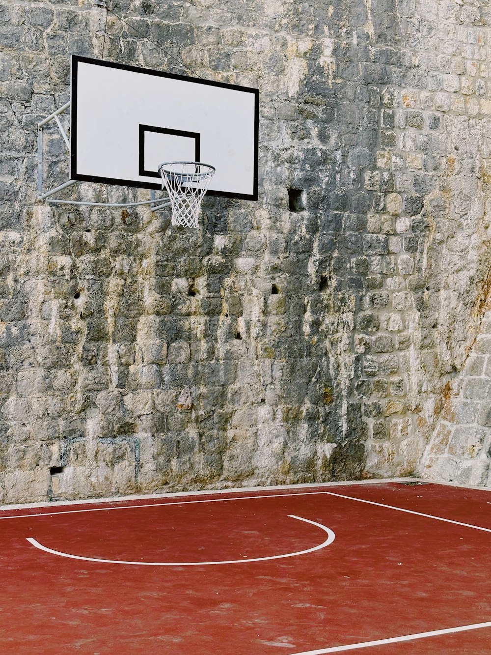 a basketball court in front of a brick wall