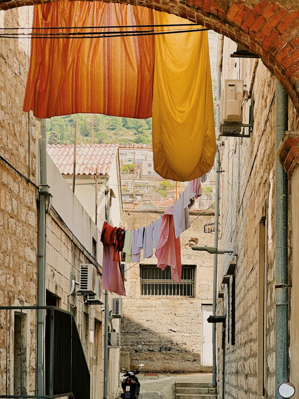 a man riding a motorcycle down a narrow alley way