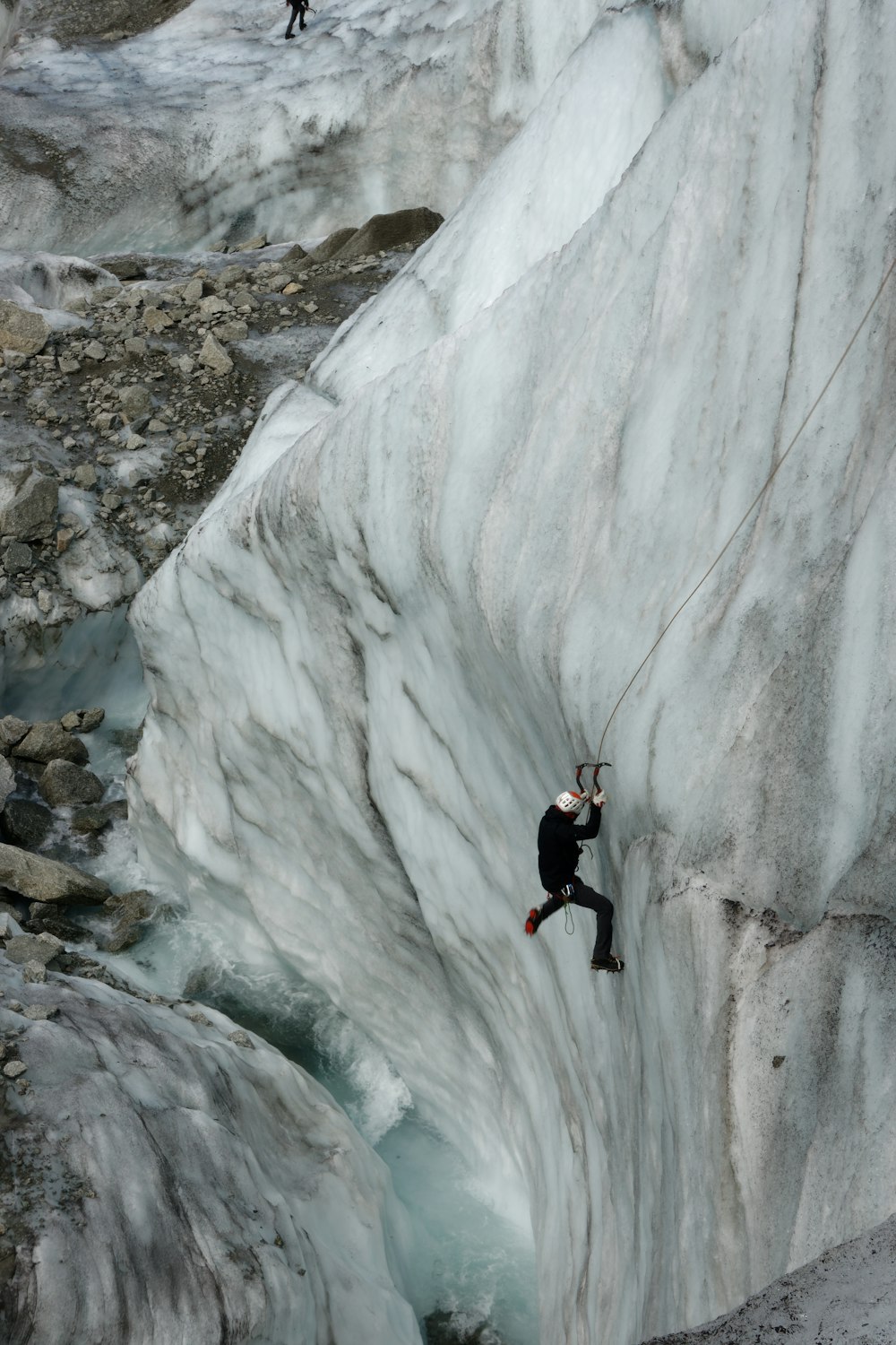 a man climbing up the side of a snow covered mountain