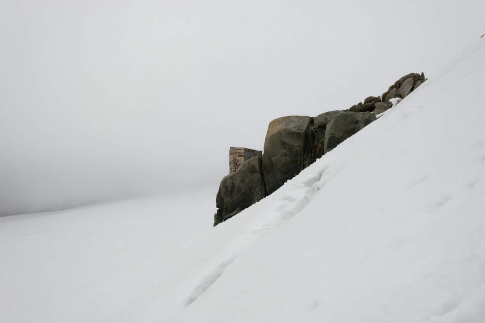 a snow covered hill with rocks on top of it