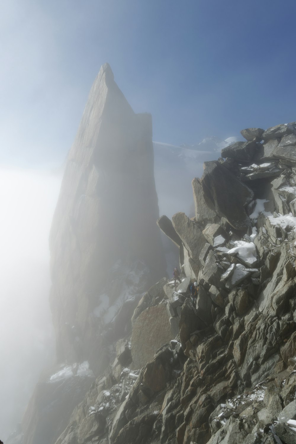 Una montaña rocosa cubierta de nieve y niebla
