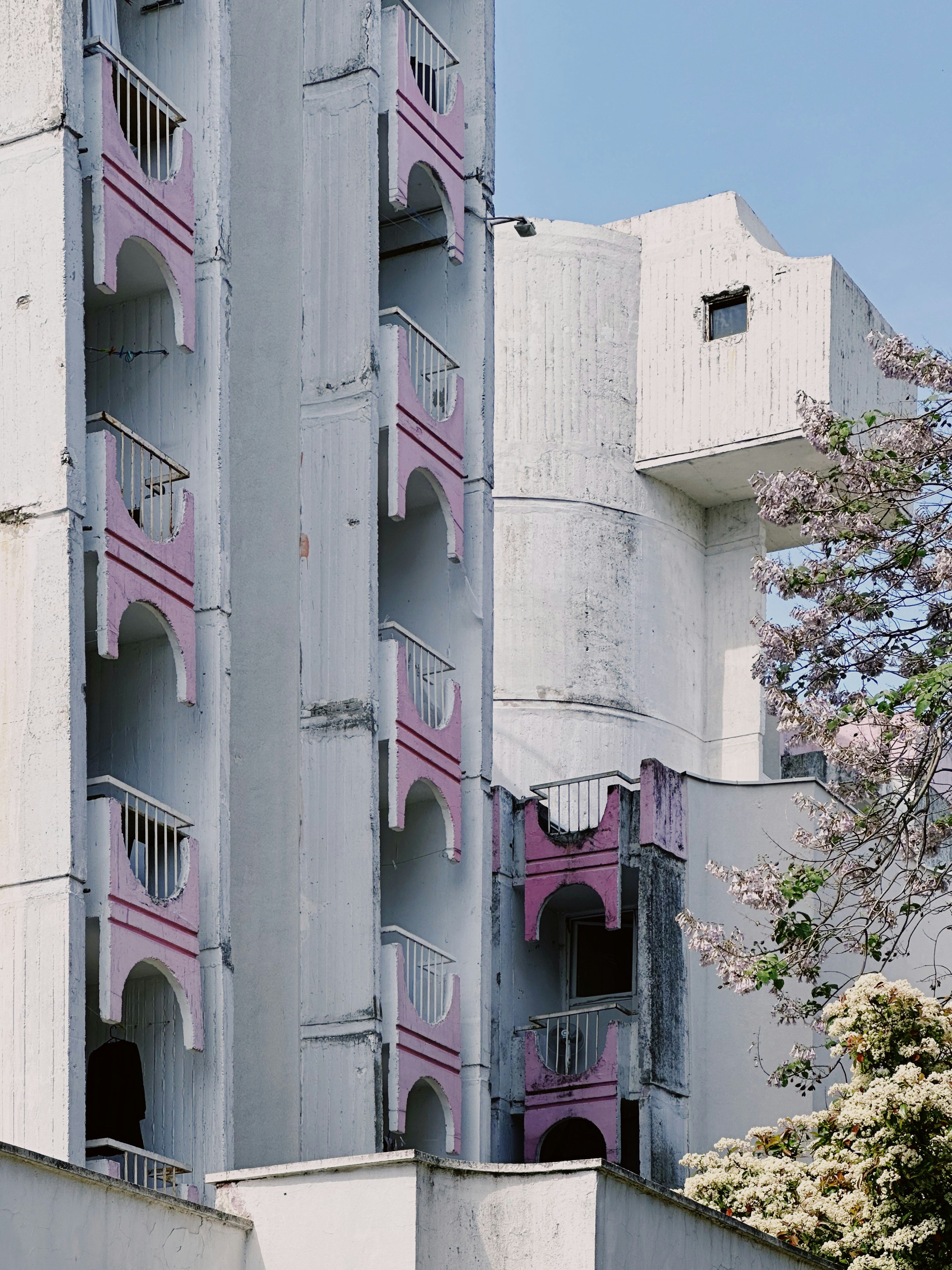 a tall building with balconies and balconies painted pink