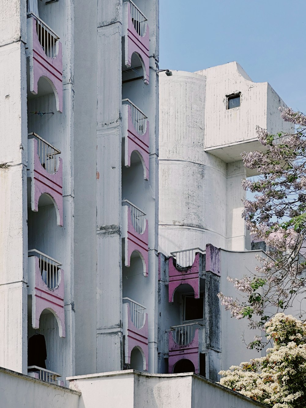 a tall building with balconies and balconies painted pink