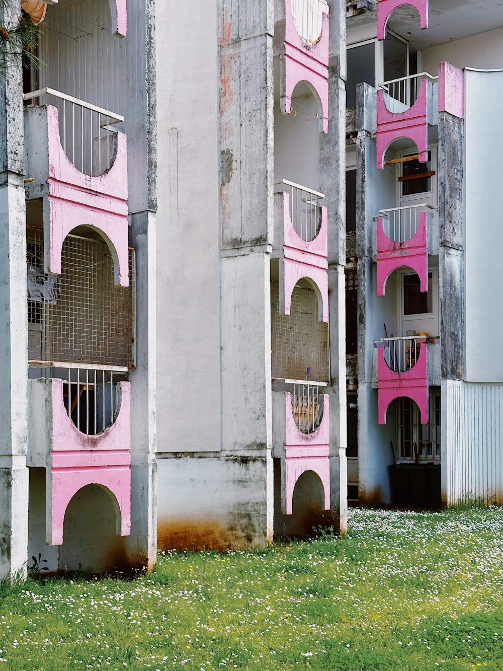 Una hilera de edificios rosados y blancos con balcones