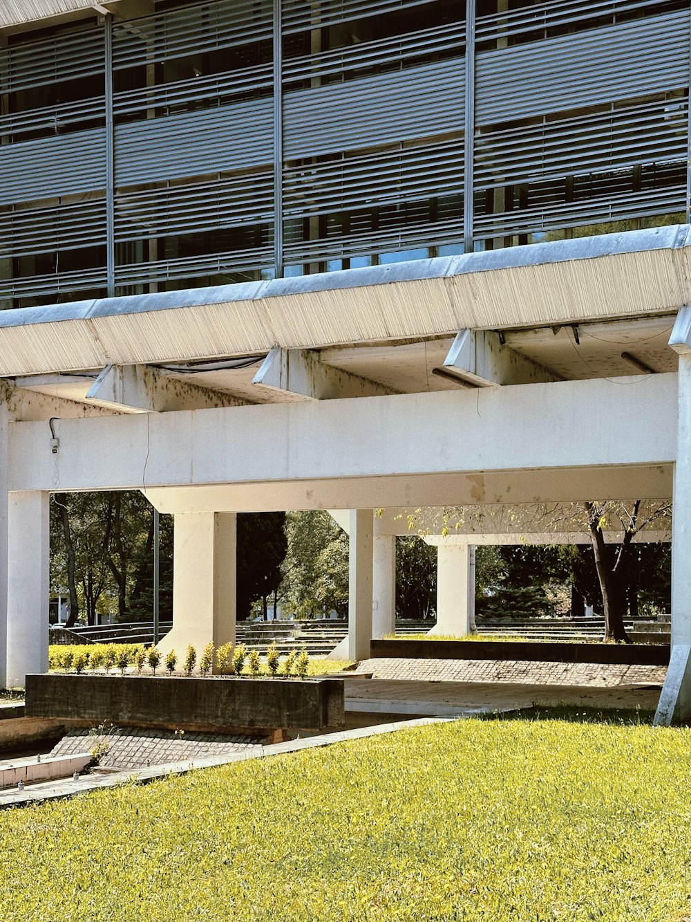 a white building with a balcony and a green lawn