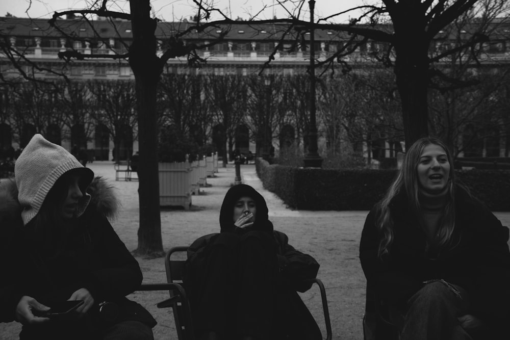 a group of people sitting on a bench in a park