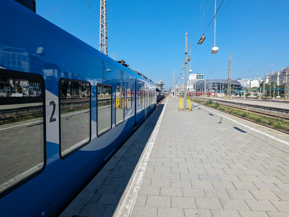 a blue train stopped at a train station
