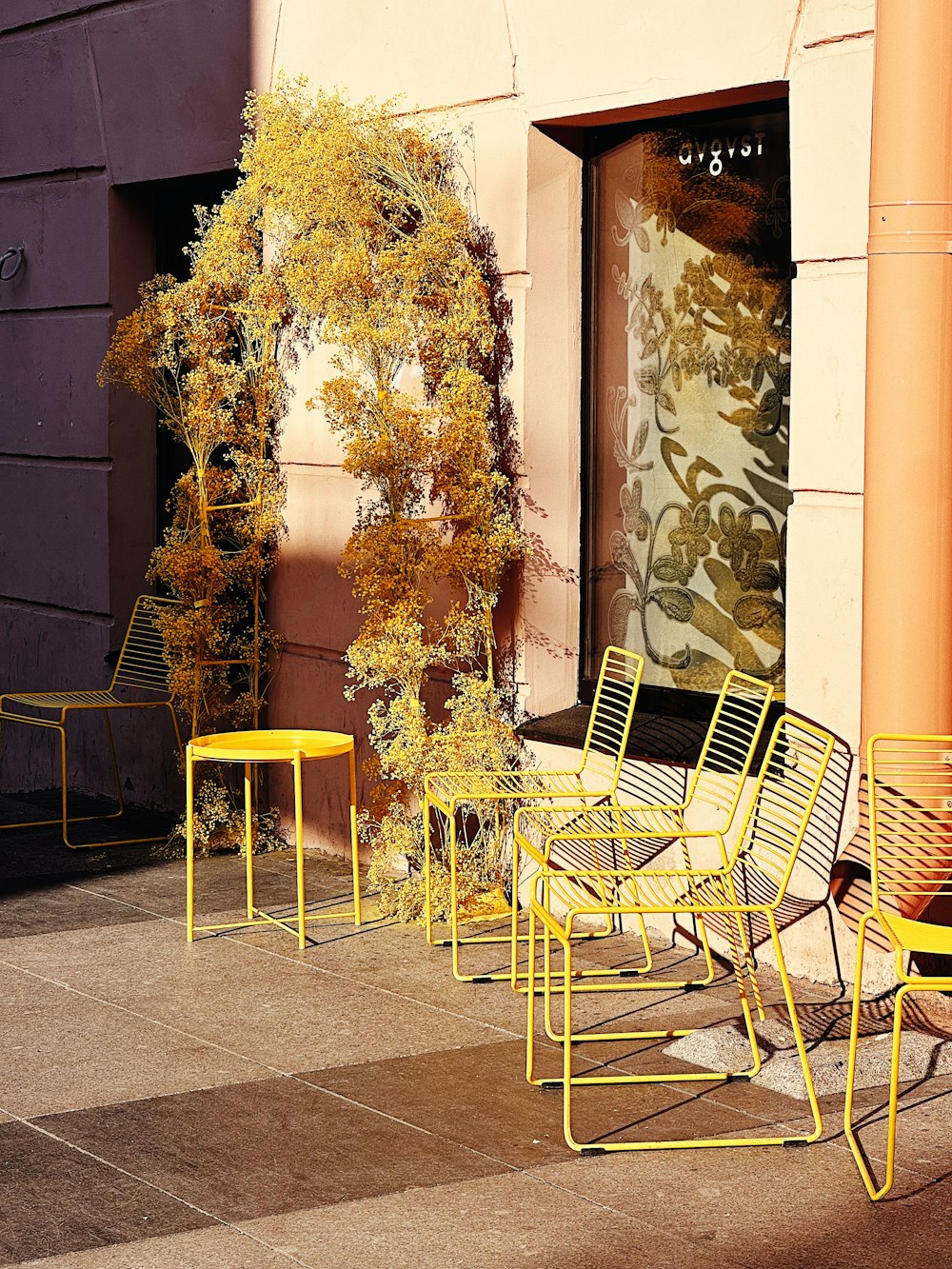 a row of yellow chairs sitting on top of a sidewalk