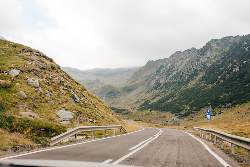 a car driving down a road in the mountains