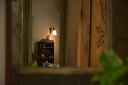 A cozy living room corner showcasing warm lighting and elegant decorative pieces arranged on wooden shelves.