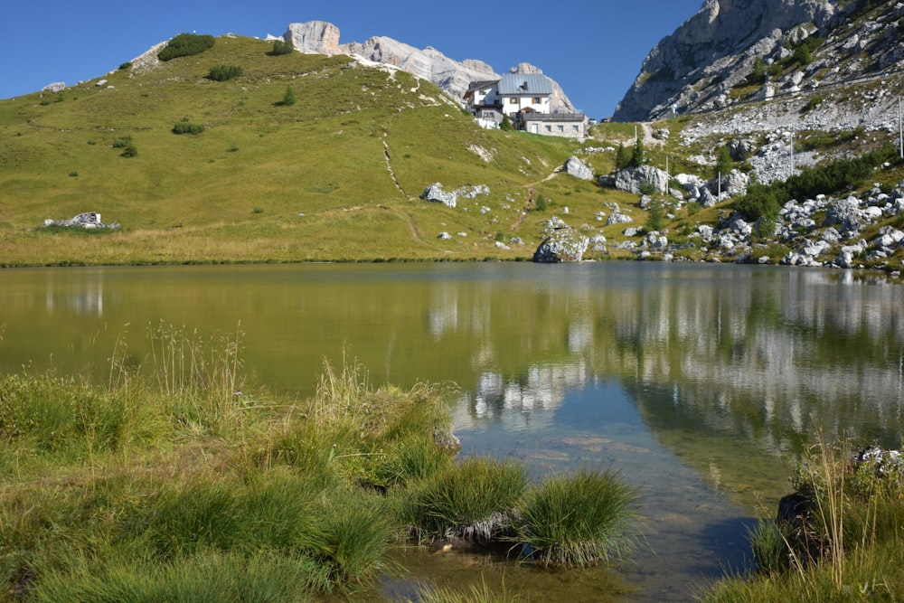 a small lake surrounded by a lush green hillside