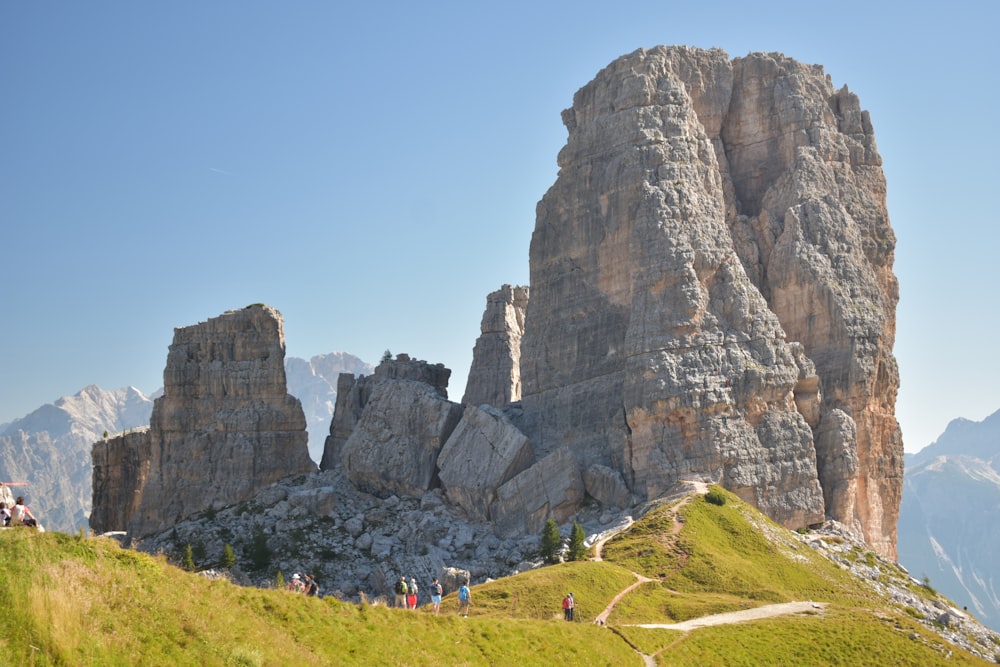 a group of people standing on top of a lush green hillside