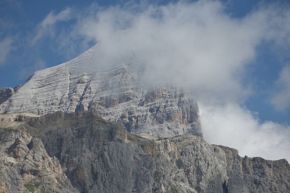 a very tall mountain with some clouds in the sky