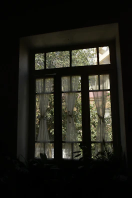 Tie-back curtains gently framing a bright window with garden views.