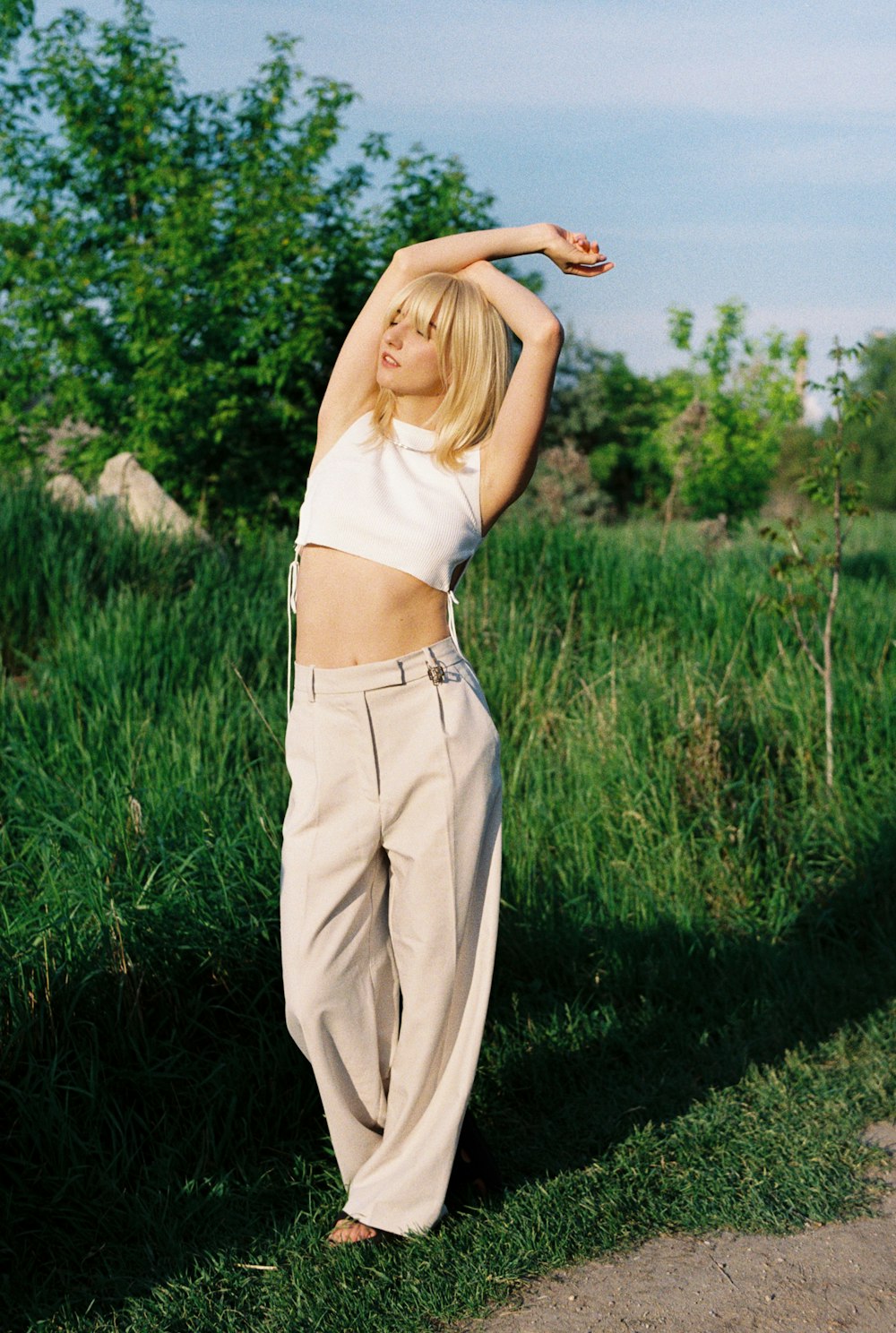 a woman standing in a field with her arms in the air