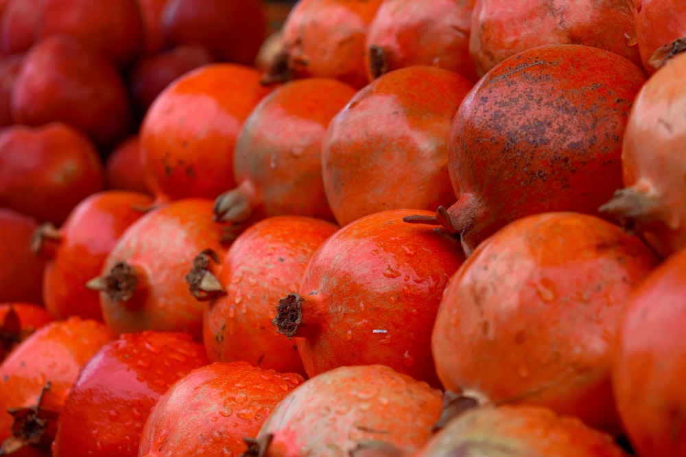 a pile of red pomegranates sitting on top of each other