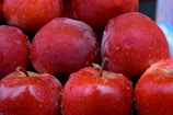 a pile of red apples sitting on top of each other