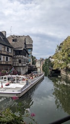 a boat traveling down a river next to tall buildings