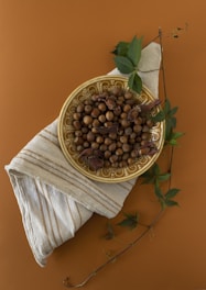a bowl of nuts on a napkin on a table