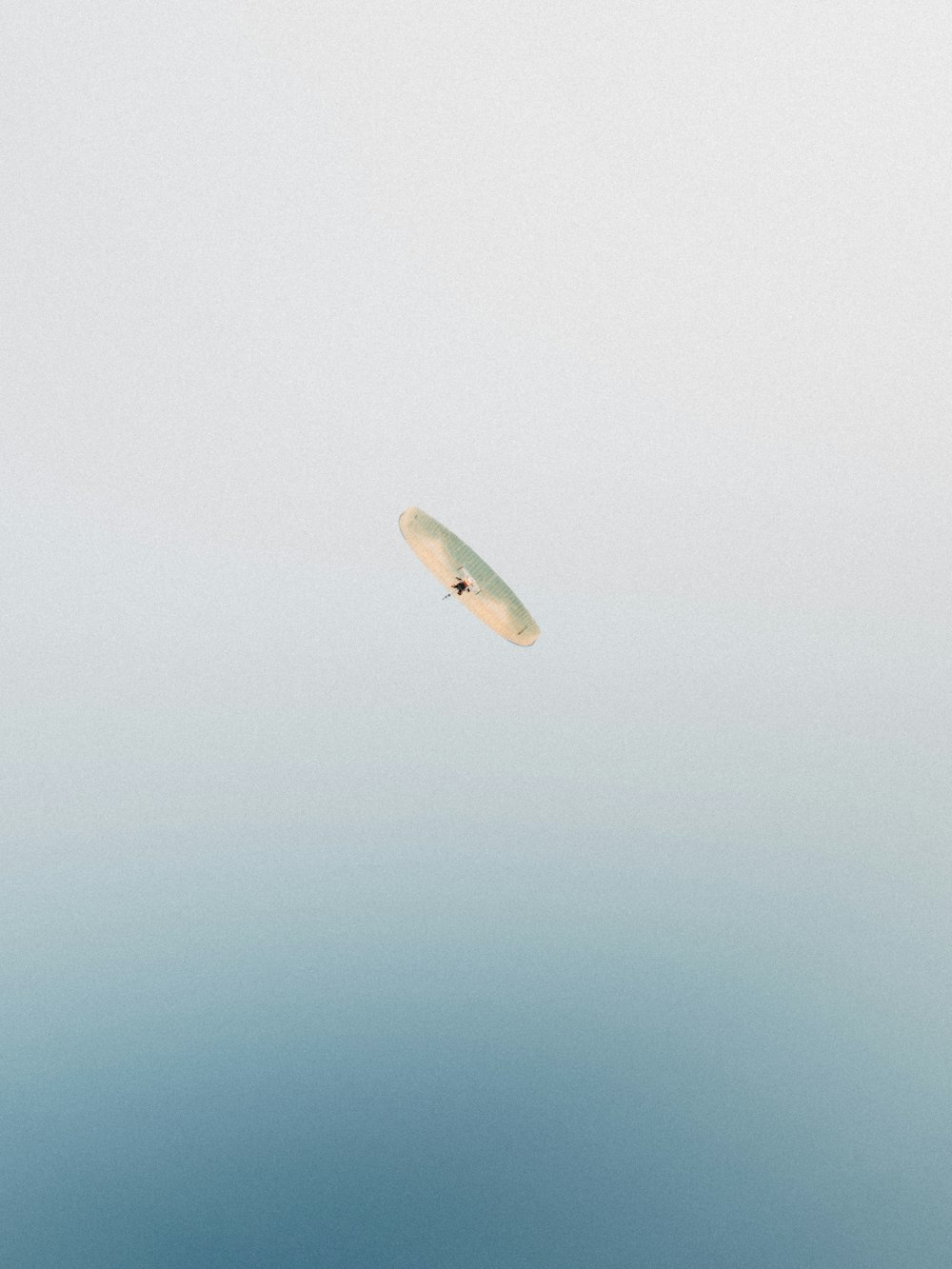 a white frisbee flying through the air on a cloudy day