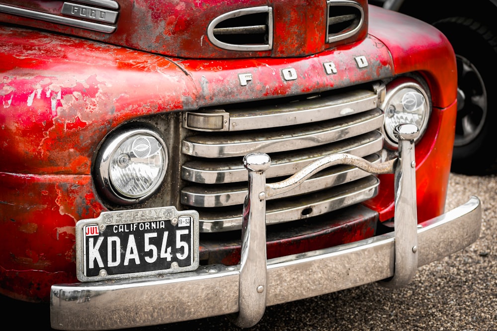 an old red truck with a license plate on it