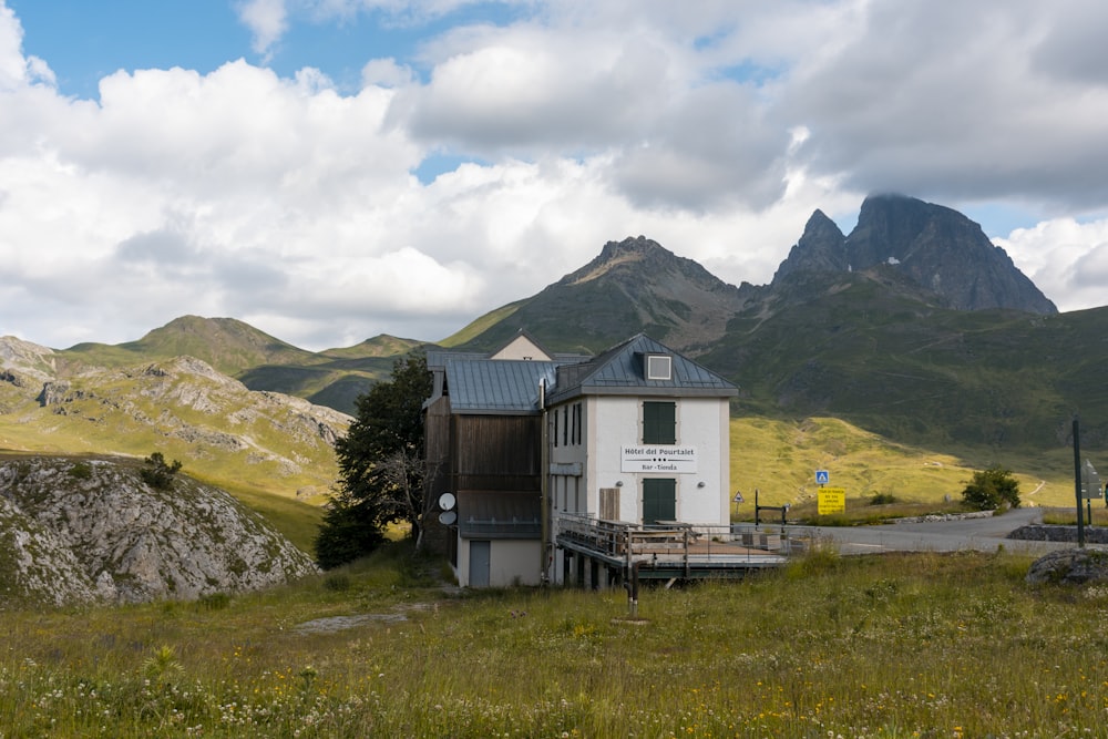 a house in a field with mountains in the background