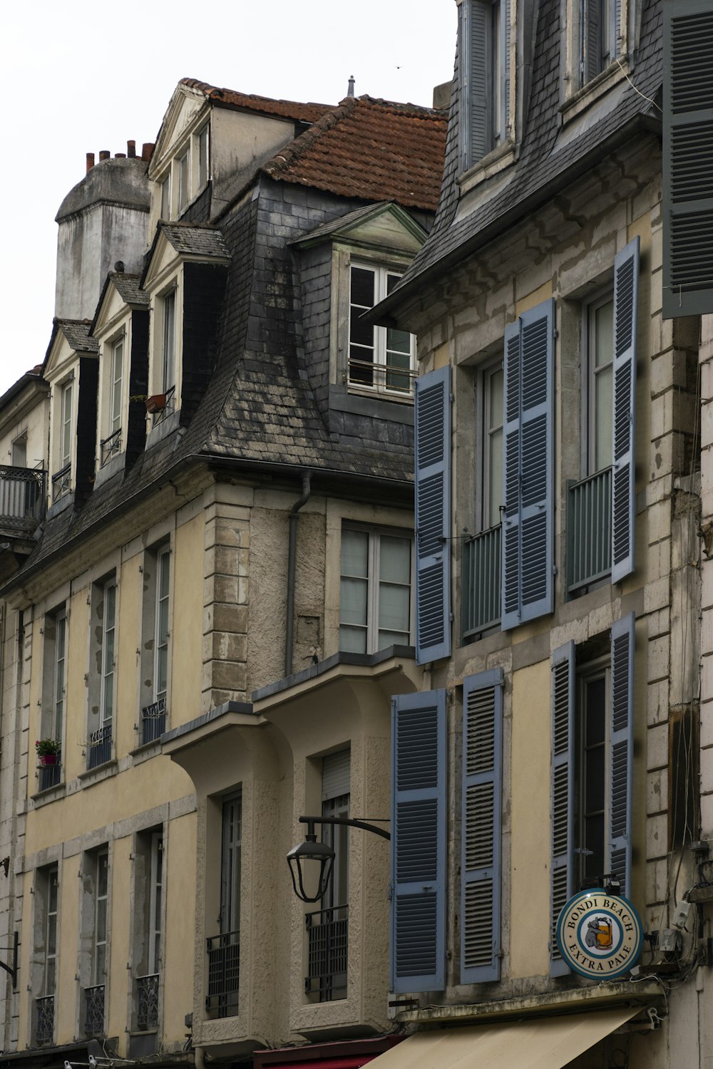 a row of buildings with blue shutters and a clock