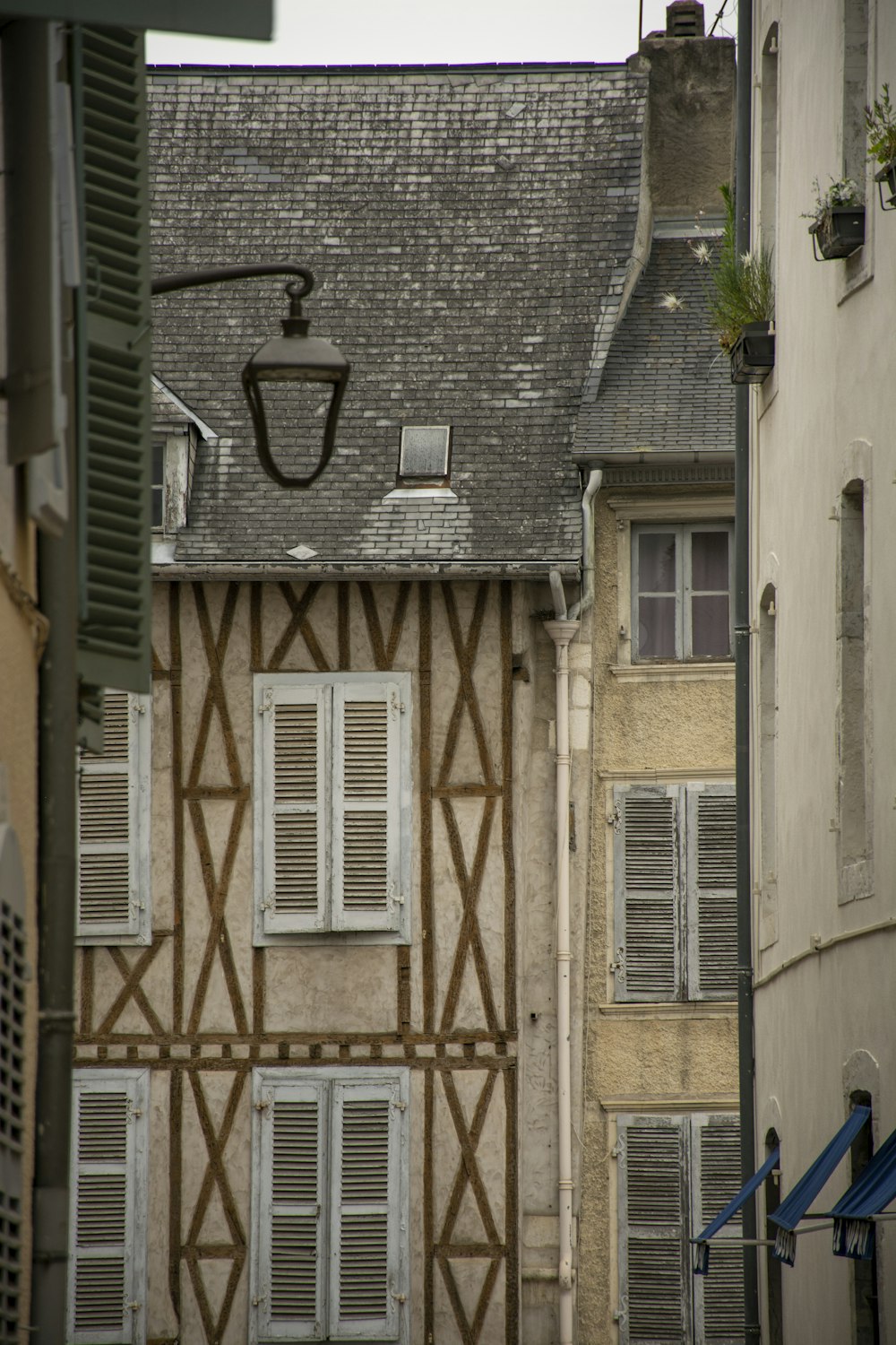 a building with shutters and a basketball hoop above it