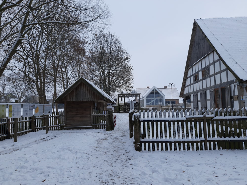ein schneebedeckter Hof mit einem Holzzaun