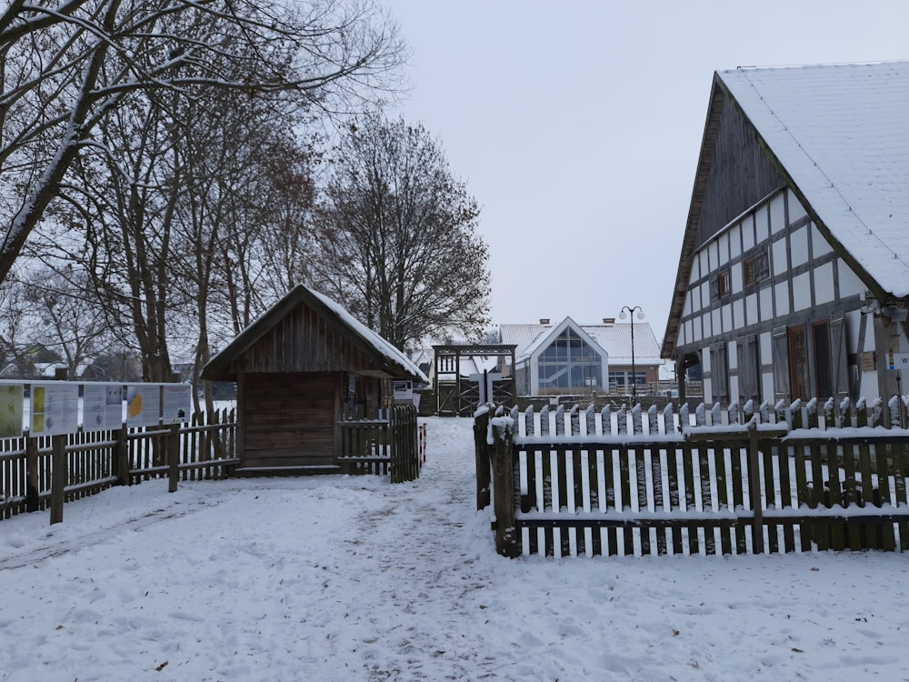 a snow covered yard with a wooden fence