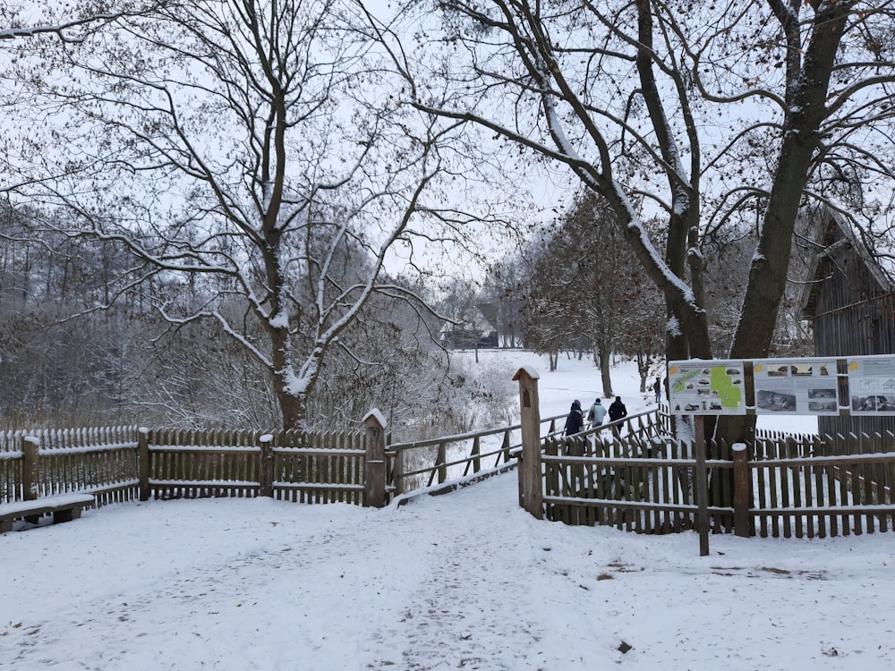 a wooden fence with a sign on it in the snow