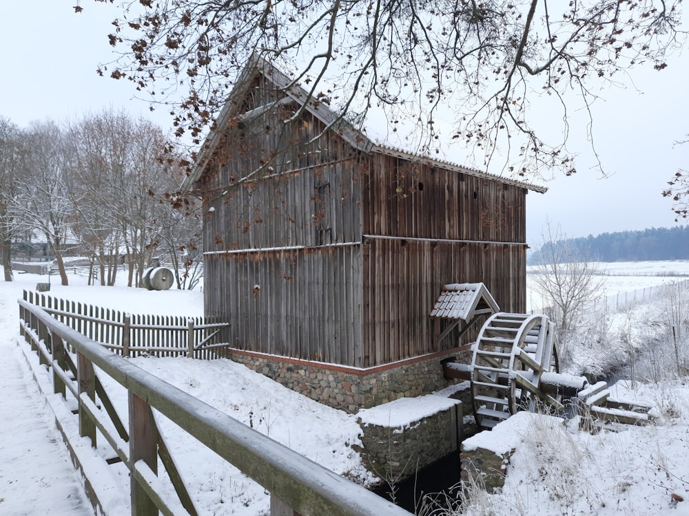 a wooden building sitting on top of a snow covered field