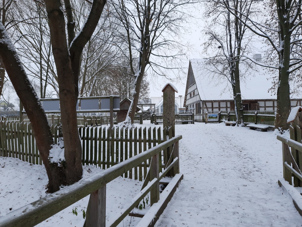 a snowy path leading to a wooden fence