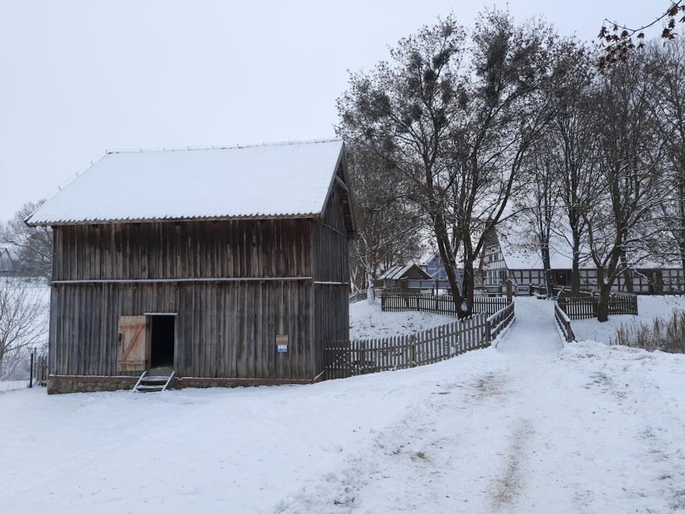 a snow covered path leading to a barn