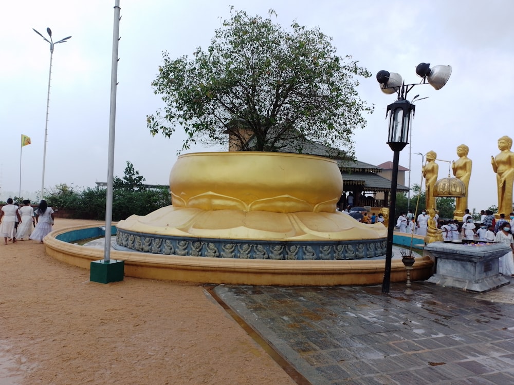 a group of people standing around a golden statue