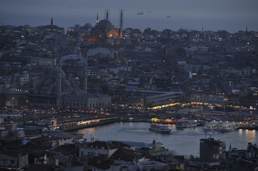 a view of a city at night with boats in the water