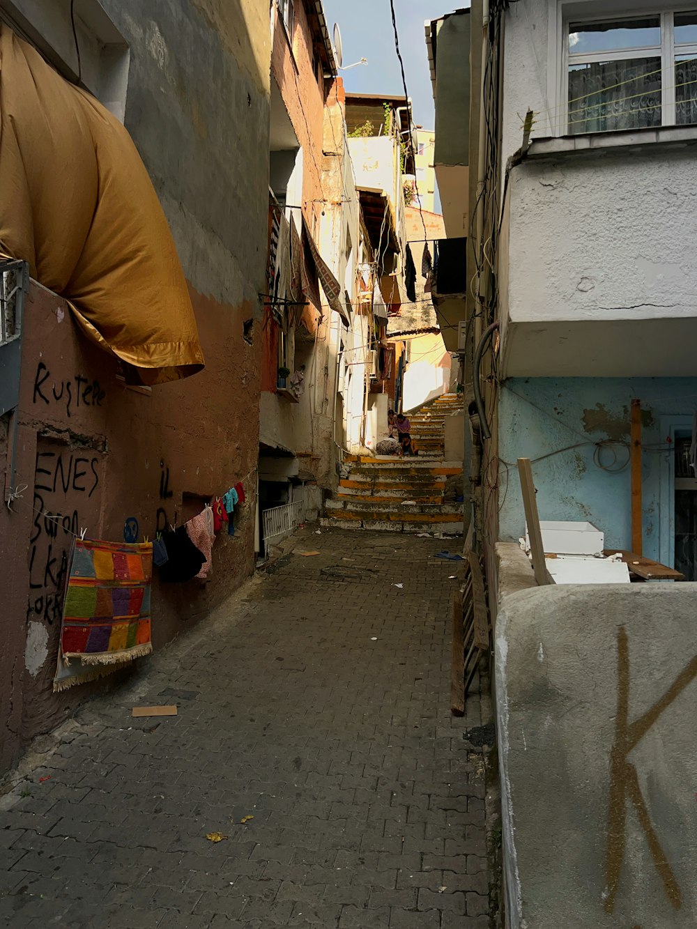 a narrow alleyway with graffiti on the walls