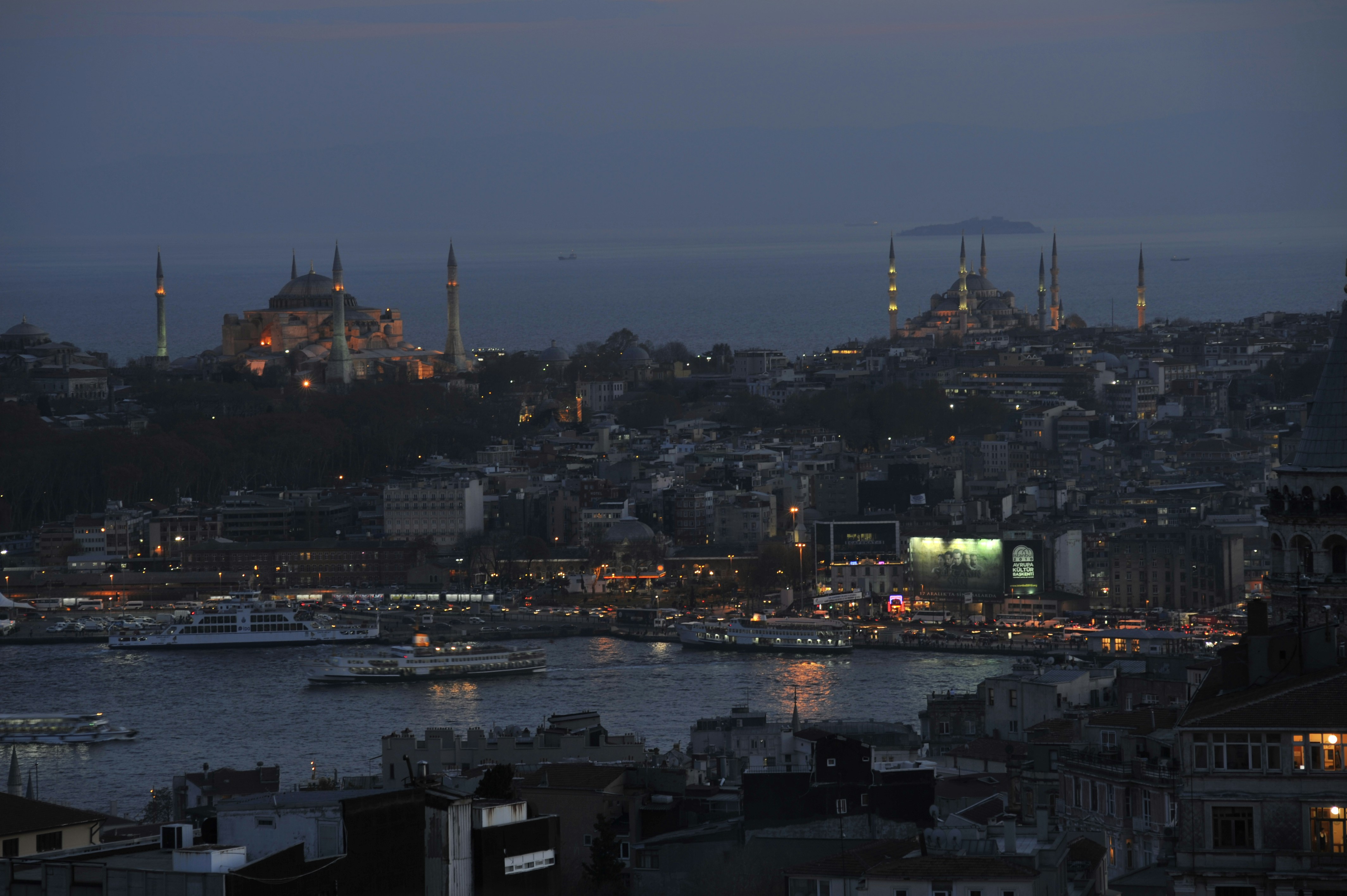 a view of a city at night with boats in the water