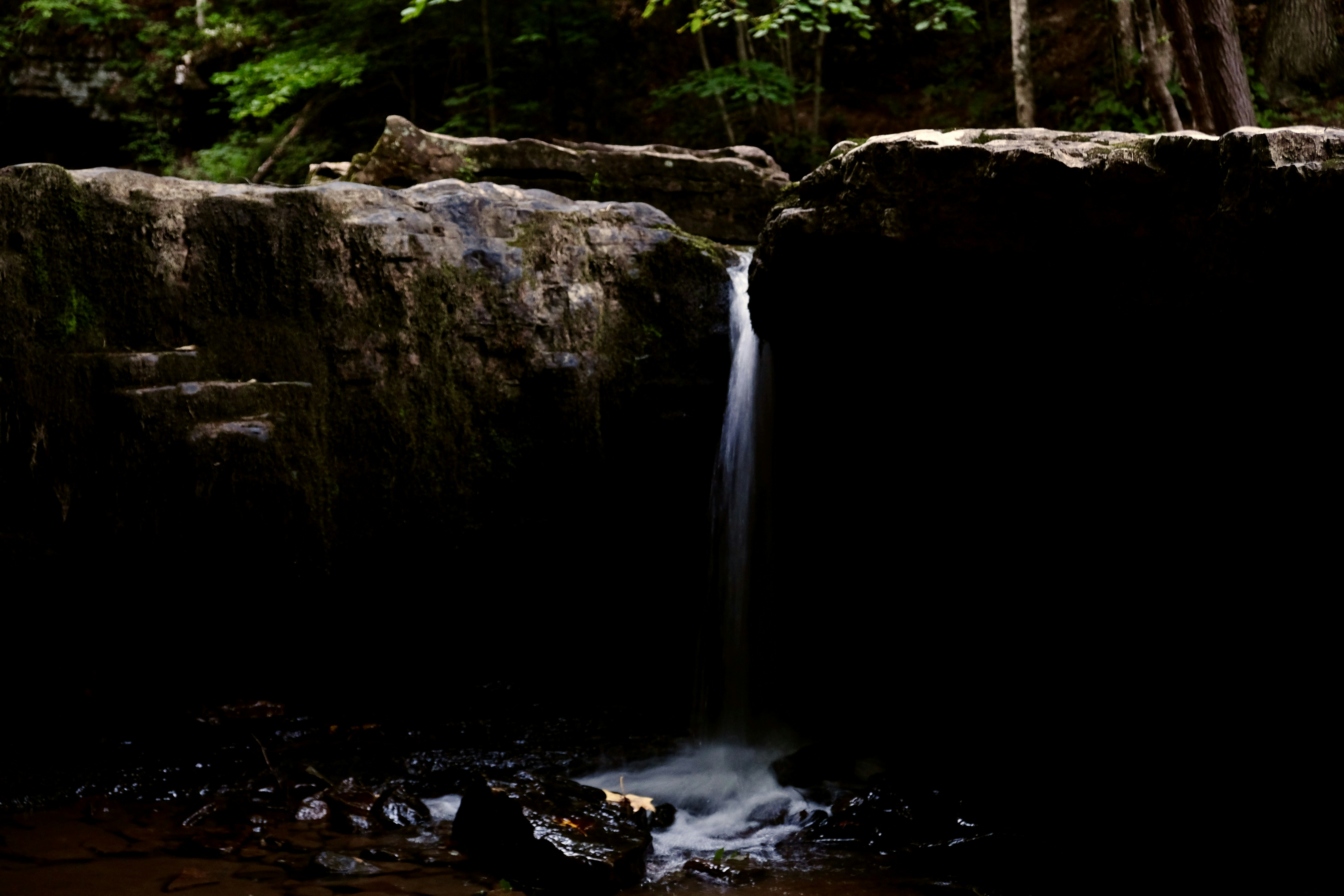 a small waterfall in the middle of a forest