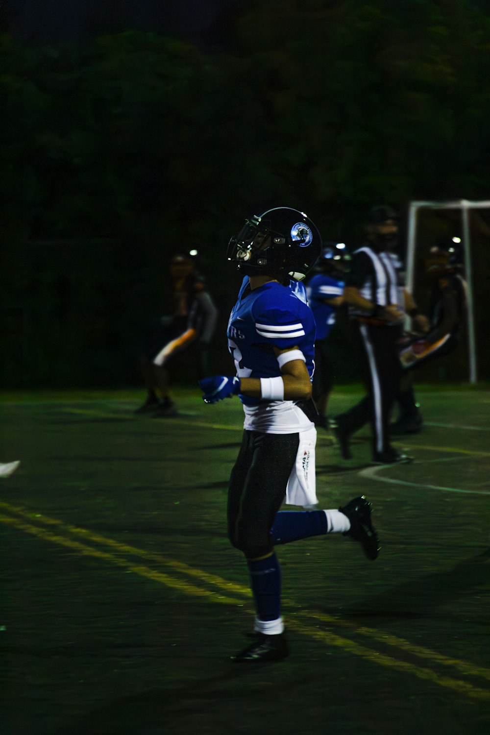 a football player running on a field at night