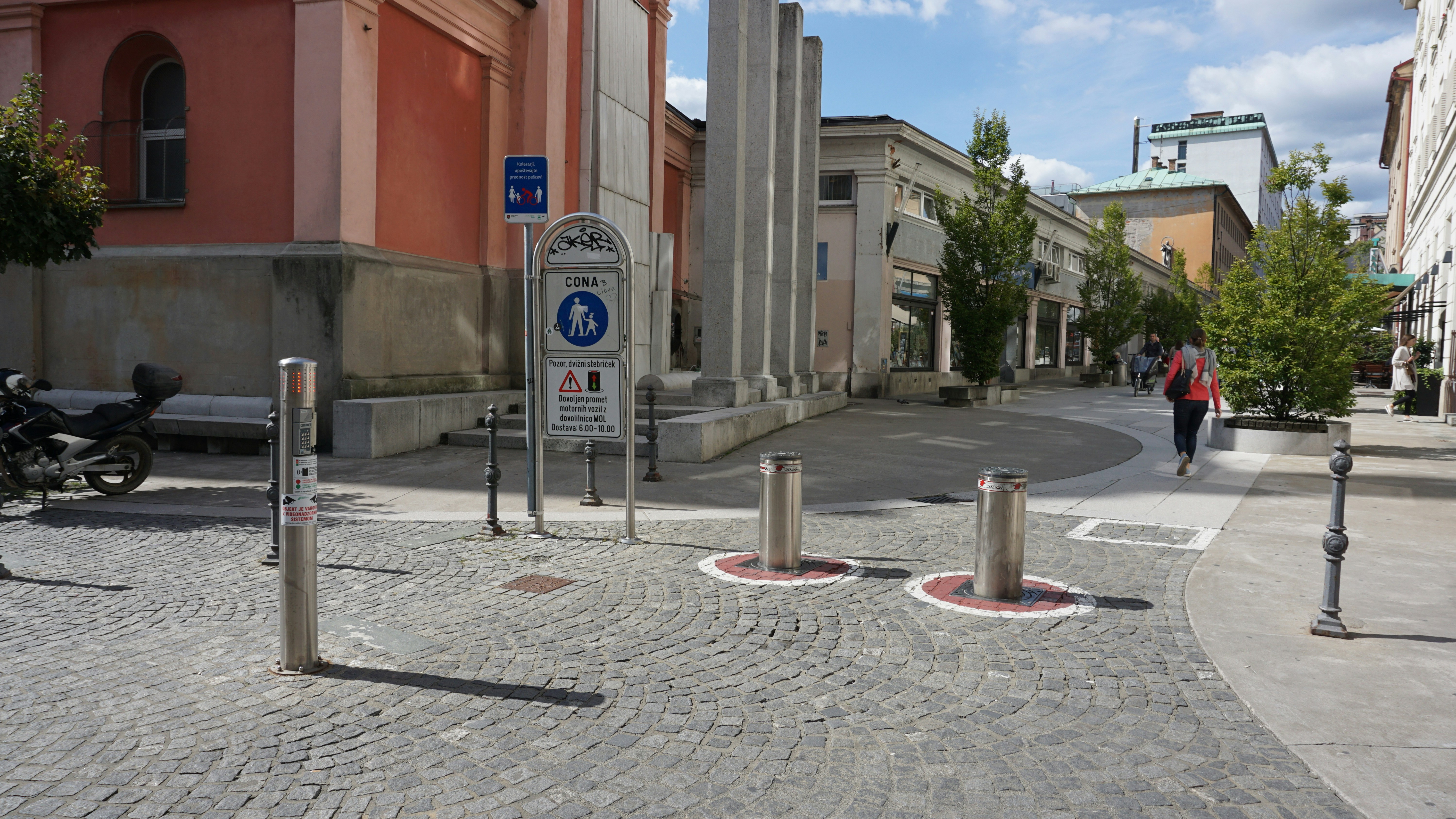 a man walking down a street next to tall buildings