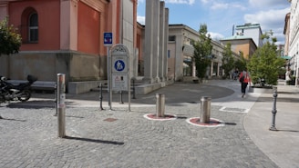 a man walking down a street next to tall buildings