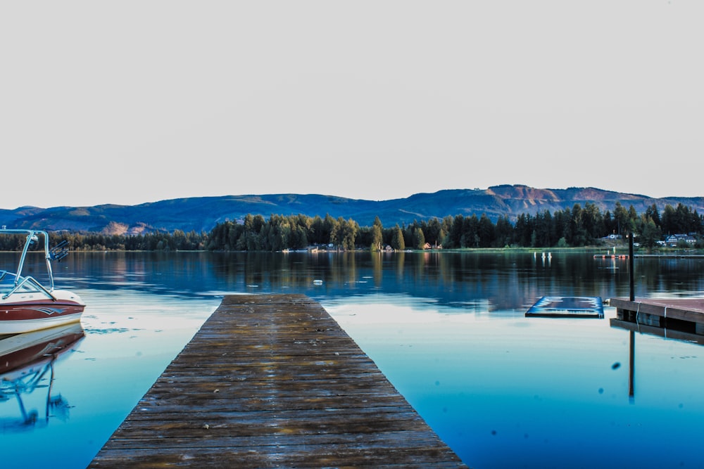 a dock on a lake with a boat in the water