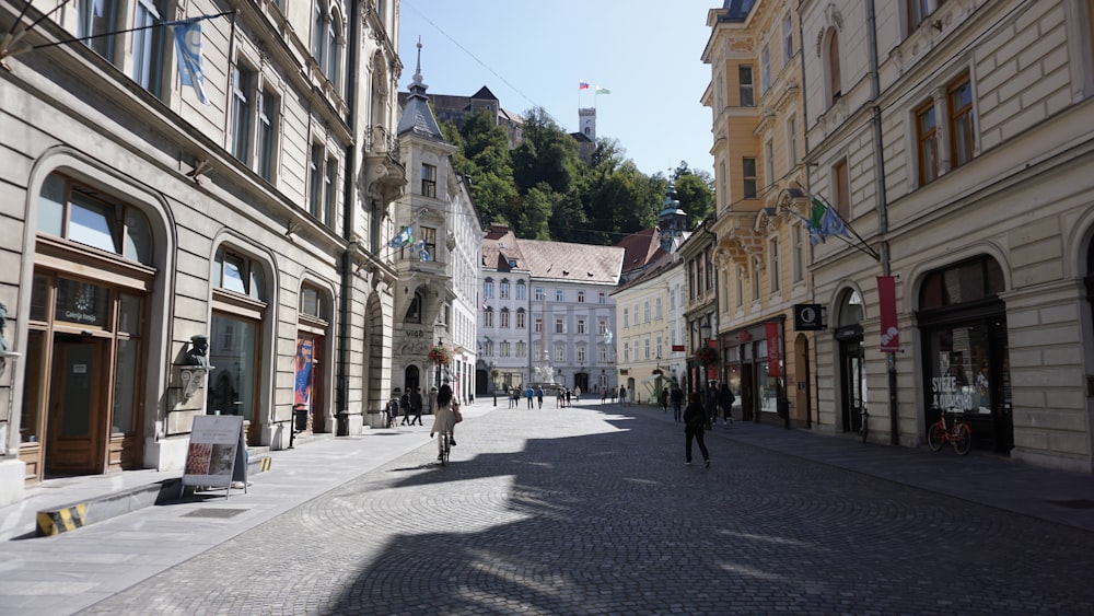 a person riding a bike down a cobblestone street