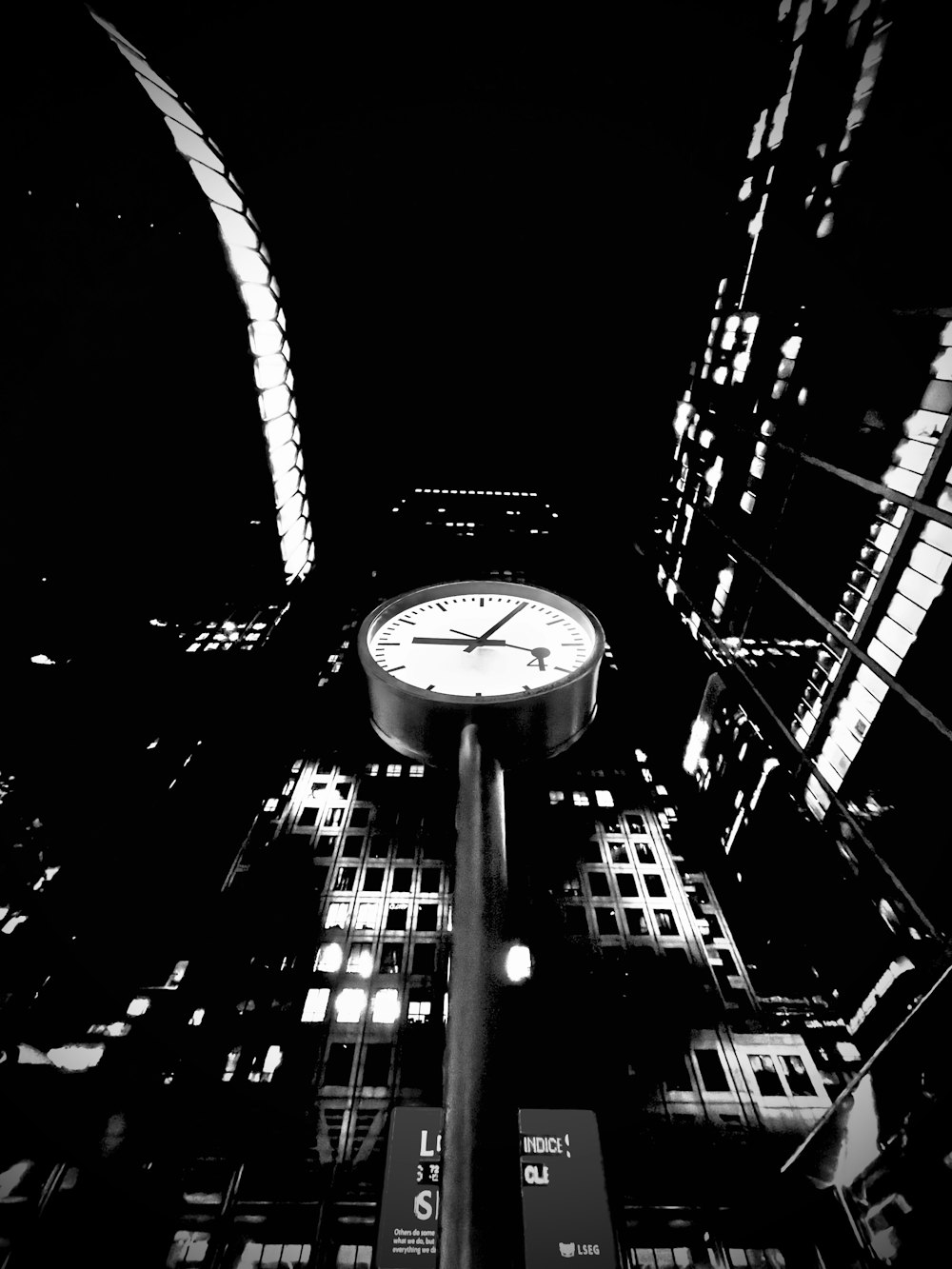 도시 한복판에 있는 시계의 흑백 사진