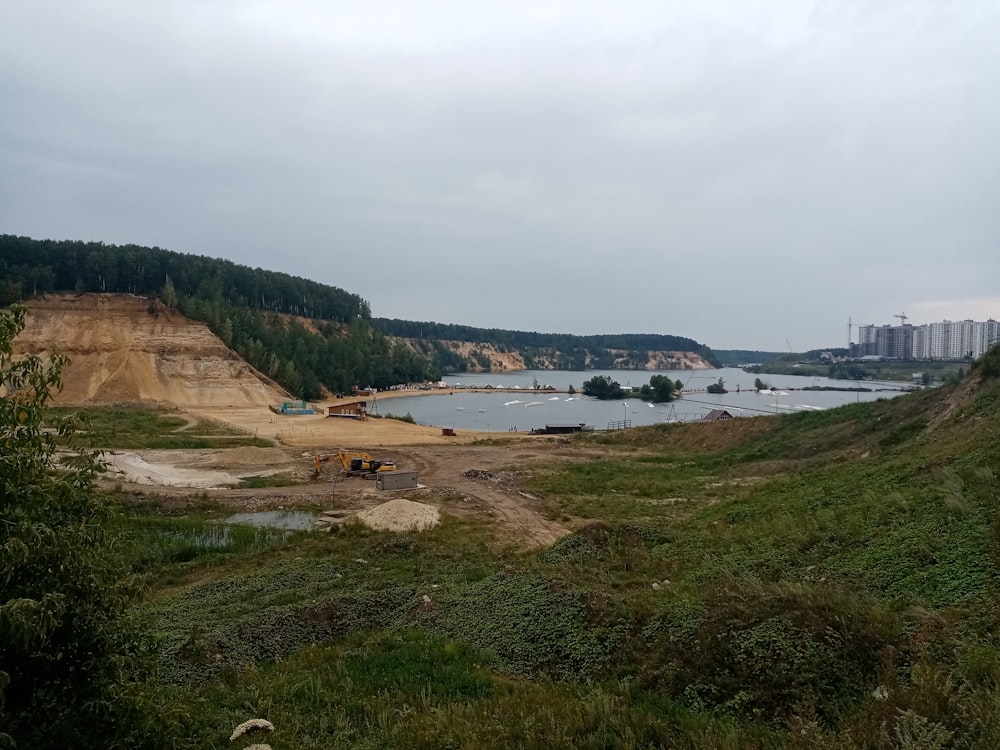 a large body of water sitting next to a lush green hillside