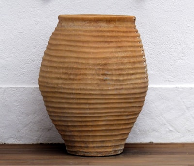 Elegant handcrafted ceramic planter with subtle earthy glaze on a soft neutral background.